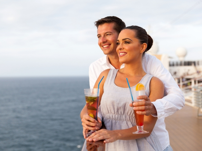 couple on cruise holding cocktails