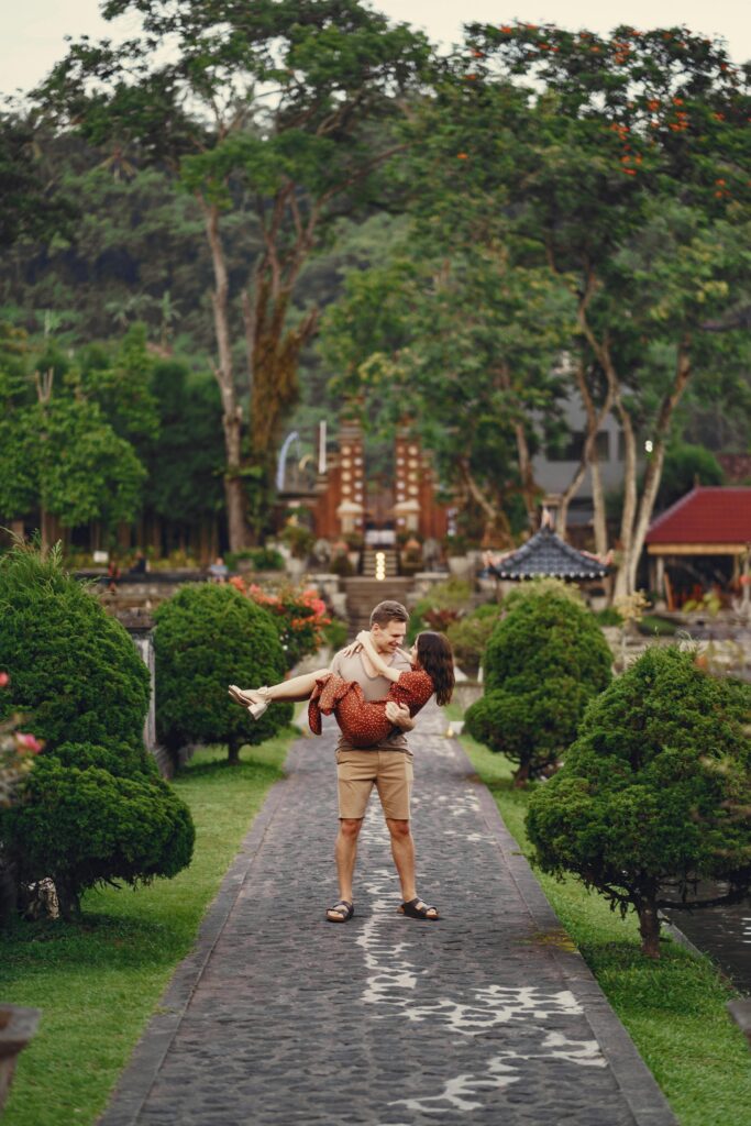 man carrying woman down romantic garden path