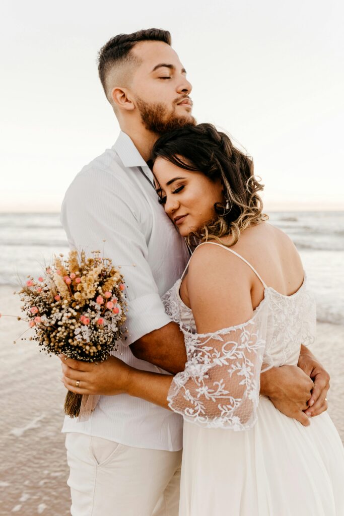 bride and groom embracing on beach