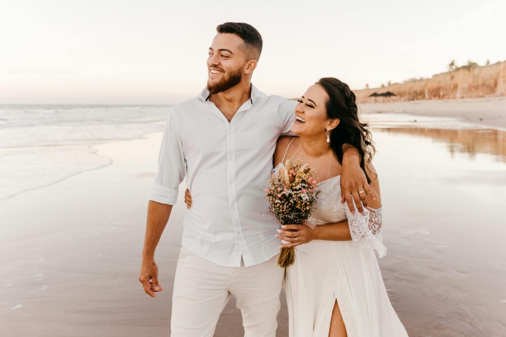 couple laughing during beach wedding