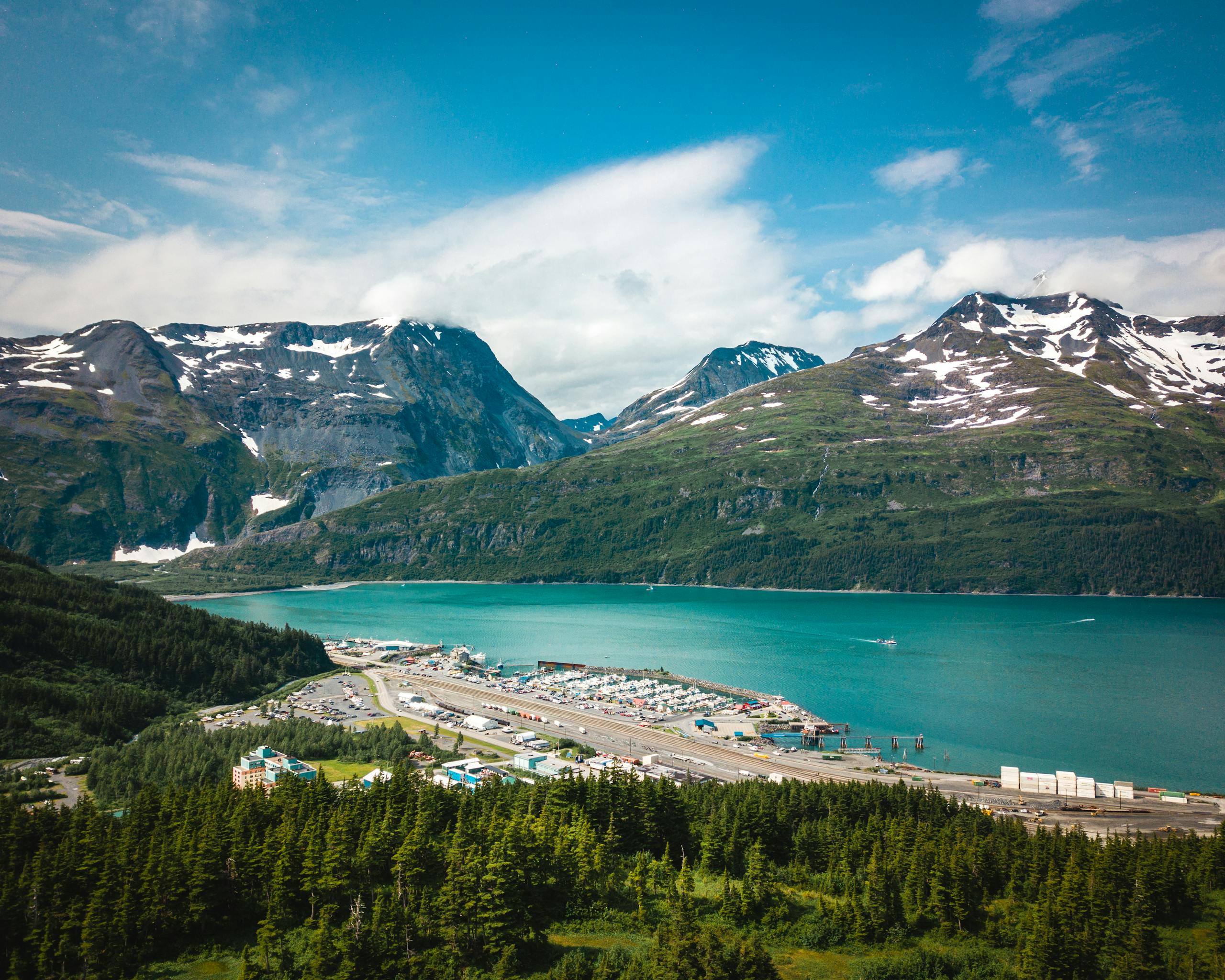 Scenic aerial view of a fjord surrounded by snow-capped mountains in Alaska, USA.